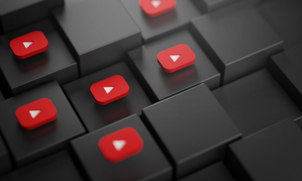 Des icônes rouges de YouTube avec des flèches blanches sur un fond de carrés noirs en perspective.